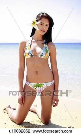 Stock Image - Young woman in bikini on beach. Fotosearch