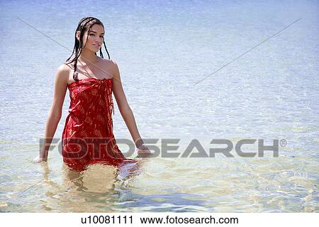 Stock Image - Young woman posing in water. Fotosearch