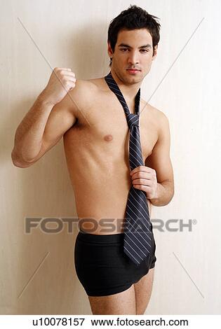 Stock Photo - Bare chested young man posing with shorts and tie. Fotosearch