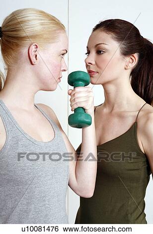 Two young women with dumbbell View Large Photo Image Stock Photograph - Two young women with dumbbell. Fotosearch