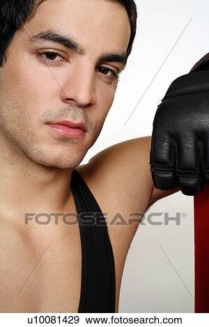 Stock Photo - Young man leaning on punching bag. Fotosearch