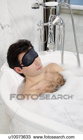 Stock Image - Man enjoying bubble bath. Fotosearch