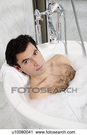Stock Image - Man enjoying bubble bath. Fotosearch