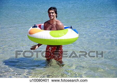 Man in the water with inflatable life ring View Large Photo Image Stock Image - Man in the water with inflatable life ring. Fotosearch