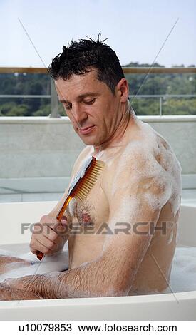 Stock Image - Man relaxing in bathtub with bubbles. Fotosearch