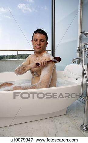 Stock Photo - Man relaxing in bathtub with bubbles. Fotosearch