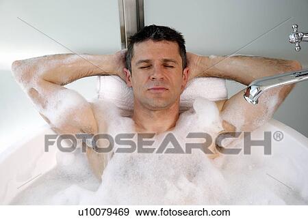 Stock Photo - Man relaxing in bathtub with bubbles. Fotosearch