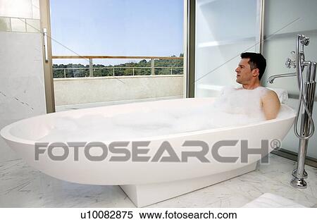 Stock Photography - Man relaxing in bathtub with bubbles. Fotosearch