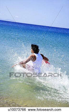 Stock Photograph - Man splashing through water. Fotosearch