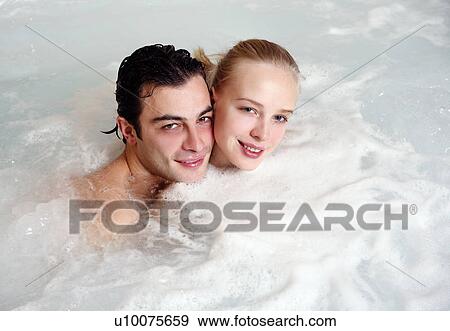 Stock Photo - One man with one woman in jacuzzi at a spa. Fotosearch