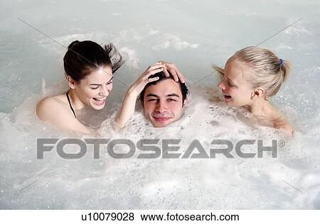 One man with two women in jacuzzi at a spa View Large Photo Image Stock Photo - One man with two women in jacuzzi at a spa. Fotosearch