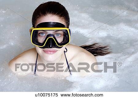 Stock Photography - One woman wearing mask in jacuzzi at a spa. Fotosearch