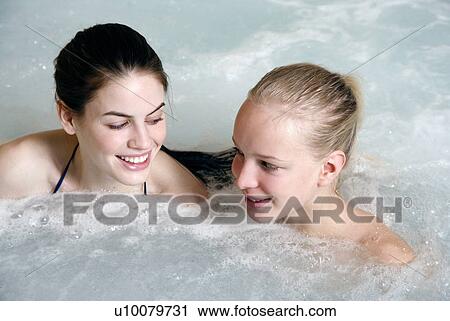 Stock Image - Two young woman in jacuzzi at a spa. Fotosearch