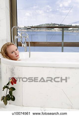 Stock Image - Woman enjoying bubble bath. Fotosearch
