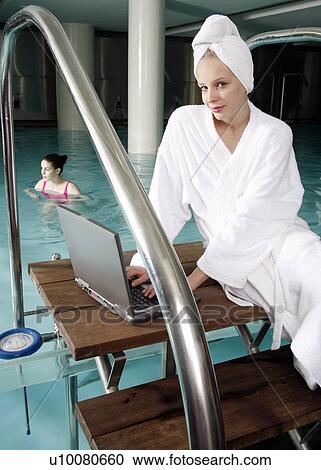 Woman on computer next to a swimming pool View Large Photo Image Stock Image - Woman on computer next to a swimming pool. Fotosearch