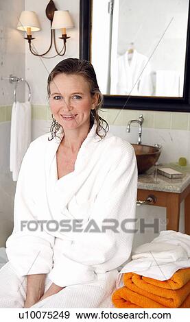 Stock Photo - Woman siting in the bathroom. Fotosearch