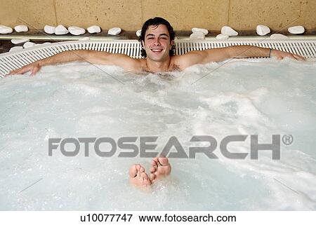 Stock Photo - Young man in jacuzzi at a spa. Fotosearch
