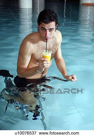 Stock Photo - Young man on exercise bike in spa pool. Fotosearch