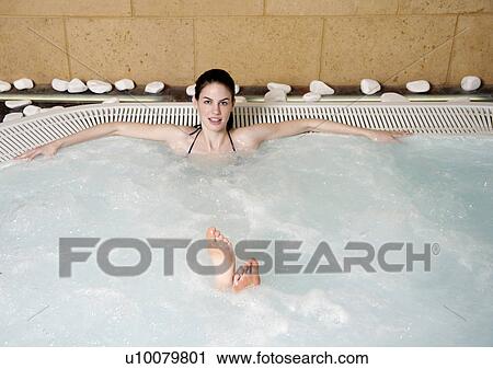 Stock Image - Young woman in jacuzzi at a spa. Fotosearch