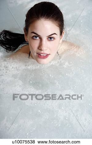 Stock Photo - Young woman in jacuzzi at a spa. Fotosearch