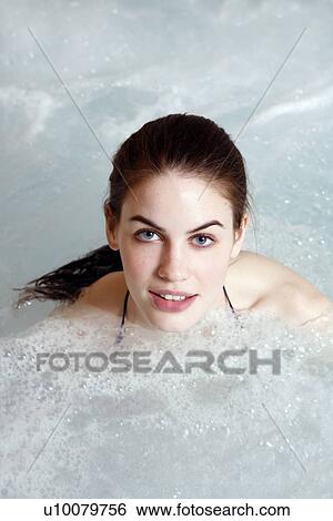 Stock Photograph - Young woman in jacuzzi at a spa. Fotosearch