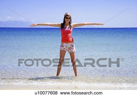 Stock Photo - Young woman in the water with arms out. Fotosearch