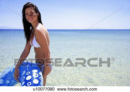 Young woman on beach with inflatable life ring View Large Photo Image Stock Image - Young woman on beach with inflatable life ring. Fotosearch