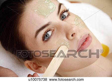 Stock Photo - Woman having a facial treatment in a spa. Fotosearch