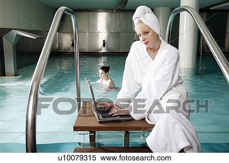 Woman on computer next to a swimming pool View Large Photo Image Stock Photography - Woman on computer next to a swimming pool. Fotosearch