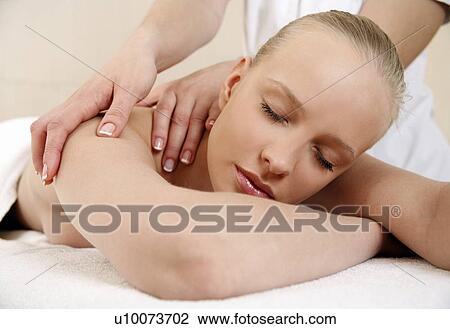 Stock Image - Young woman enjoying a massage . Fotosearch