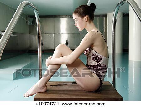 Stock Image - Young woman sitting next to spa pool. Fotosearch