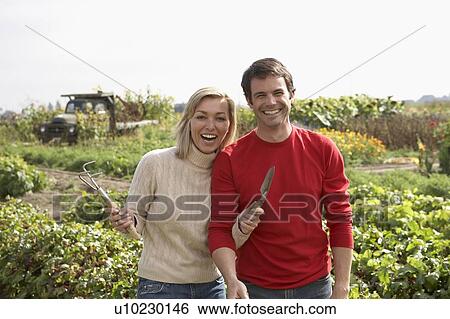 Couple with gardening tools on an organic farm, Ladner, British Columbia View Large Photo Image Stock Photograph - Couple with gardening tools on an organic farm, Ladner, British Columbia. Fotosearch