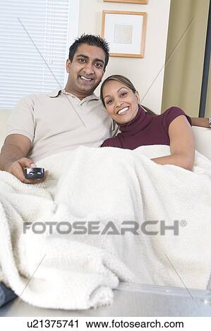 Man and woman under afghan on sofa with remote control, Winnipeg, Canada View Large Photo Image Stock Image - Man and woman under afghan on sofa with remote control, Winnipeg, Canada. Fotosearch