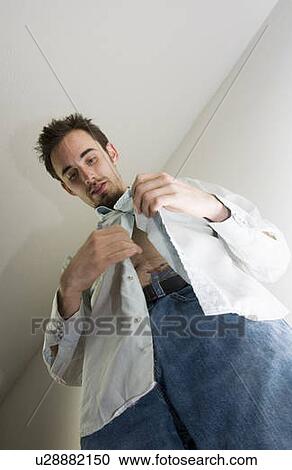 Stock Image - Man buttoning his shirt. Fotosearch