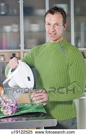 Man pouring water glass of water from filtring jug View Large Photo Image Stock Photography - Man pouring water glass of water from filtring jug. Fotosearch