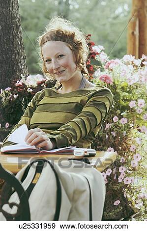 Smiling woman with notebook at outdoor restaurant, Wasagaming, Riding Mountain National Park, Manitoba, Canada View Large Photo Image Stock Photo - Smiling woman with notebook at outdoor restaurant, Wasagaming, Riding Mountain National Park, Manitoba, Canada. Fotosearch