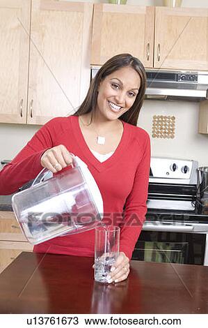 Woman pouring water from filtre jug, avoiding use of bottled water, Winnipeg, Canada, avoiding use of bottled water View Large Photo Image Stock Image - Woman pouring water from filtre jug, avoiding use of bottled water, Winnipeg, Canada, avoiding use of bottled water. Fotosearch