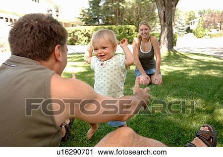 Young man & woman teaching baby to walk in grass, Regina, Saskatchewan View Large Photo Image Stock Image - Young man & woman teaching baby to walk in grass, Regina, Saskatchewan. Fotosearch