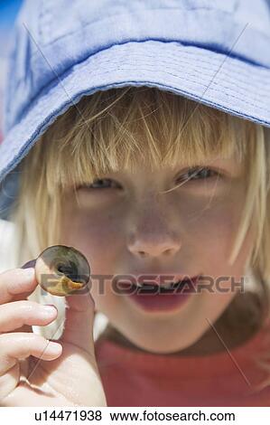 Stock Photo - 5 year old girl with a hermit crab, Monterey Bay, California. Fotosearch