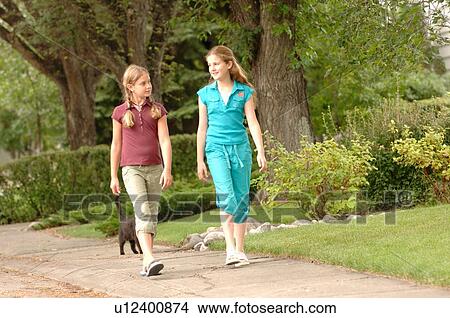 Picture - Young girls walking down street, Regina, Saskatchewan. Fotosearch
