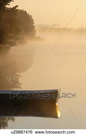 Stock Photograph - Boat and mist at Étang-à-la-Truite (Trout pond), Gaspesie, Quebec. Fotosearch