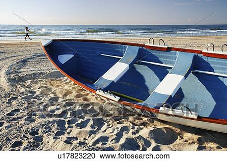 Woman walking on beach and small boat, New Jersy, USA. View Large Photo Image Stock Image - Woman walking on beach and small boat, New Jersy, USA.. Fotosearch