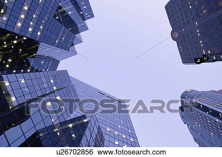 Stock Photograph - View of skyscrapers and moon on McGill College Ave at twilight, Montreal, Canada. Fotosearch
