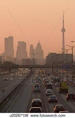 Stock Photograph - View of Toronto skyline from above Queen Elizabeth Way highway during start of rush hour traffic, Toronto, Ontario, Canada.. Fotosearch