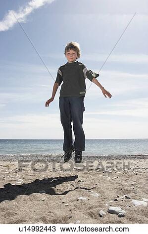 Boy jumping on beach, Whitby, Ontario. View Large Photo Image Stock Image - Boy jumping on beach, Whitby, Ontario.. Fotosearch