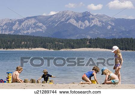 Picture - Children playing on beach on Lake Koocanusa in the East Kootenays near Fernie, British Columbia, Canada. Fotosearch