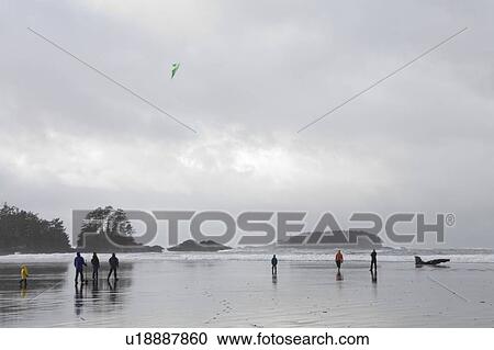 Stock Image - Family on beach flying kite in winter, Long Beach, Pacific Rim National Park, British Columbia, Canada. Fotosearch