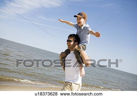 Man carries boy (7) on his shoulders, Grand Beach Provincial Park, Manitoba, Canada View Large Photo Image Stock Photo - Man carries boy (7) on his shoulders, Grand Beach Provincial Park, Manitoba, Canada. Fotosearch