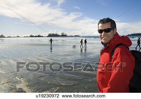Stock Image - Man strolling on beach, Chesterman Beach, Tofino, Vancouver Island, BC. Fotosearch