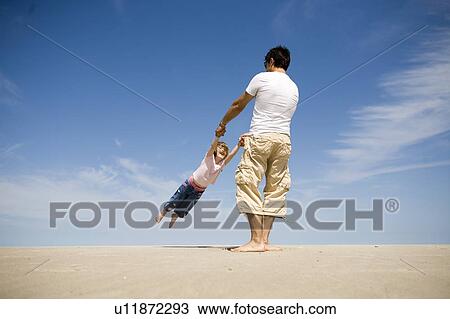 Man swings girl (4) in circle, Grand Beach Provincial Park, Manitoba, Canada View Large Photo Image Stock Image - Man swings girl (4) in circle, Grand Beach Provincial Park, Manitoba, Canada. Fotosearch